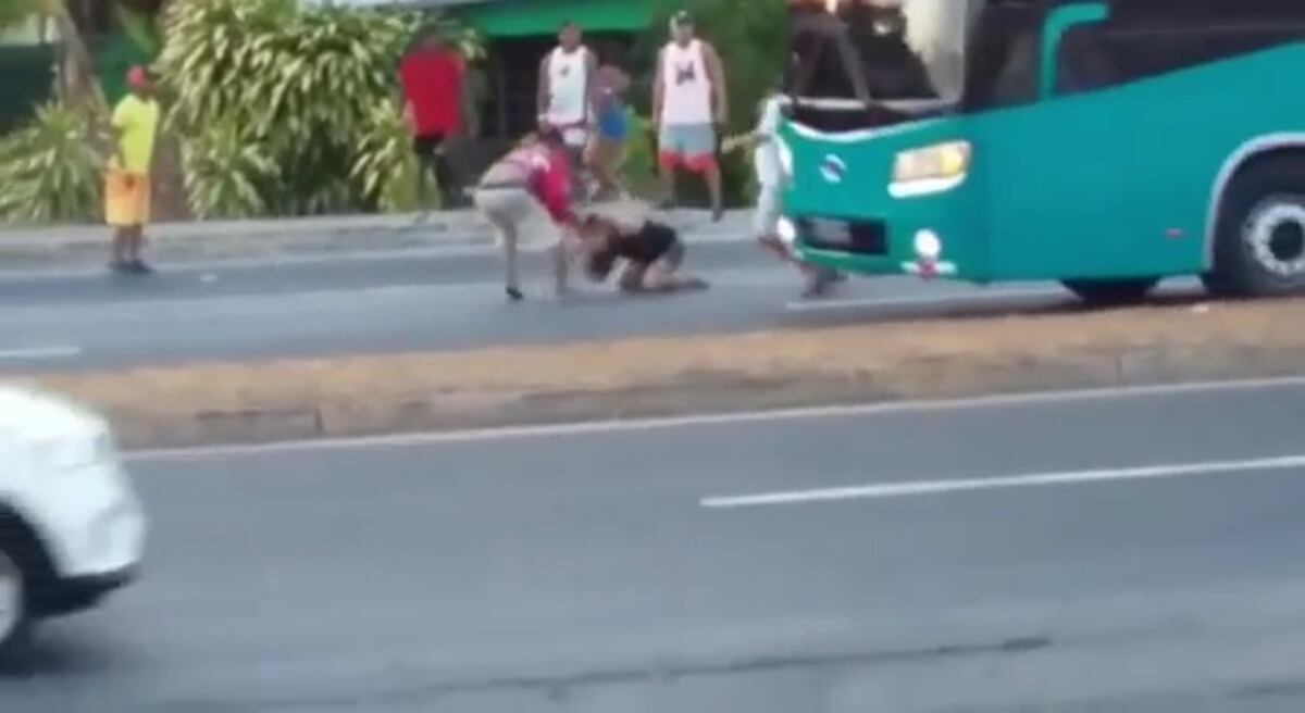 Mujer tira patadas y hombre le mete puñete en la vía.Policía lanza gas pimienta