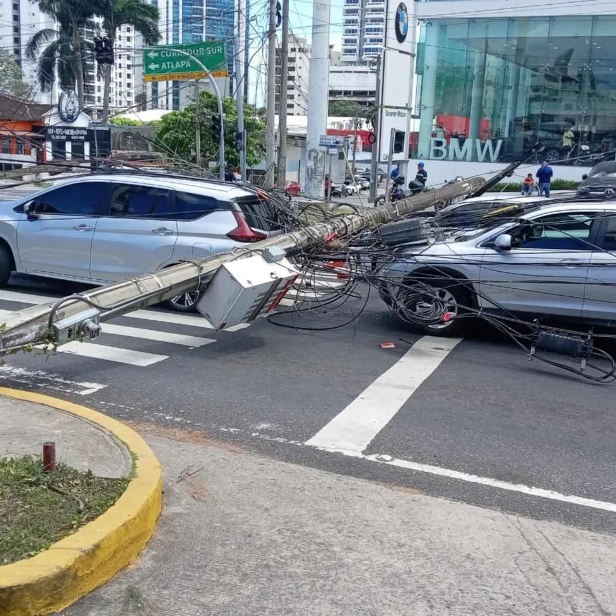Grúa se enreda con cables y provoca caída de postes sobre autos en Calle 50