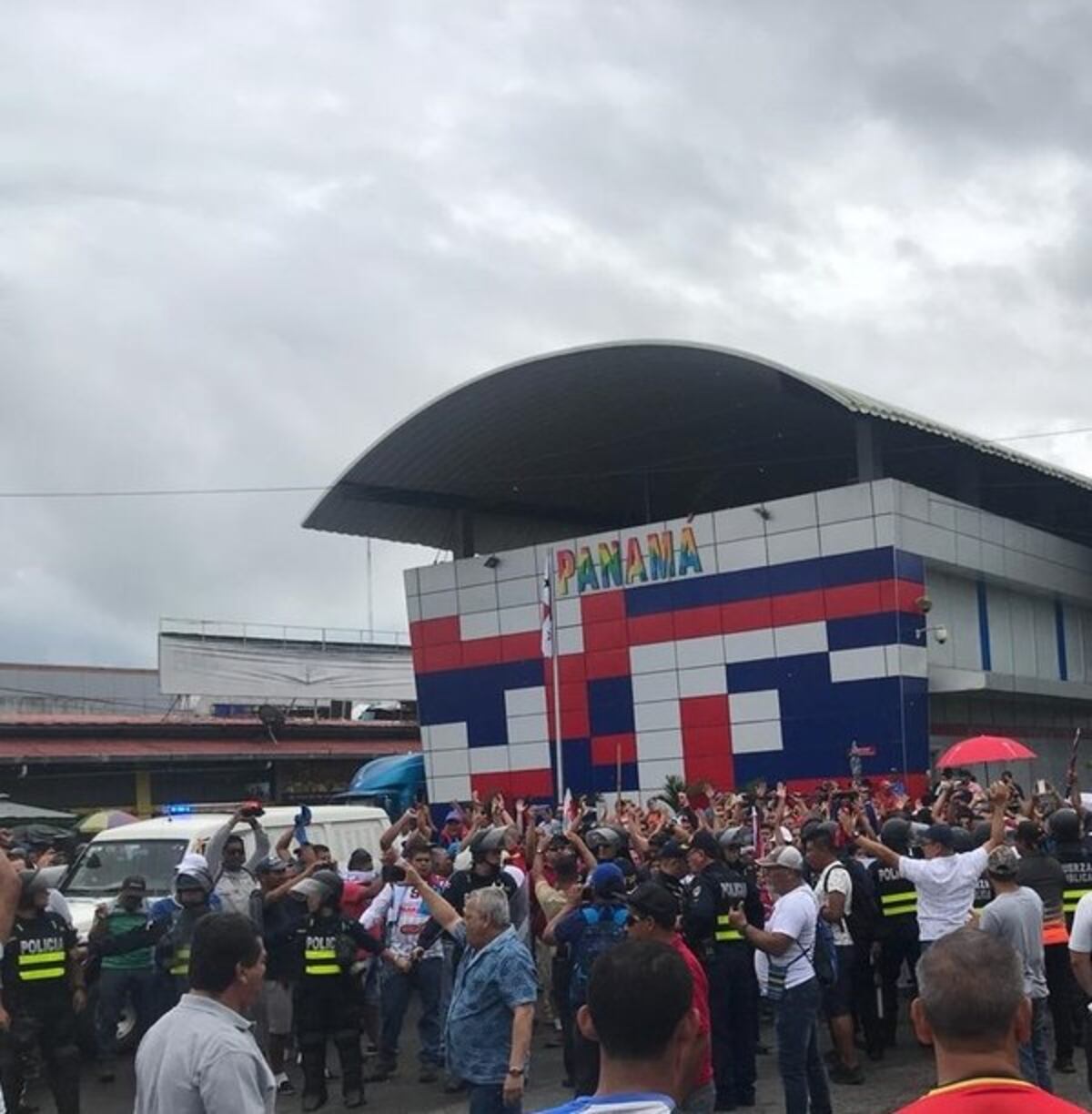 En Paso Canoas protestantes protegen a los antimotines de la lluvia con paraguas