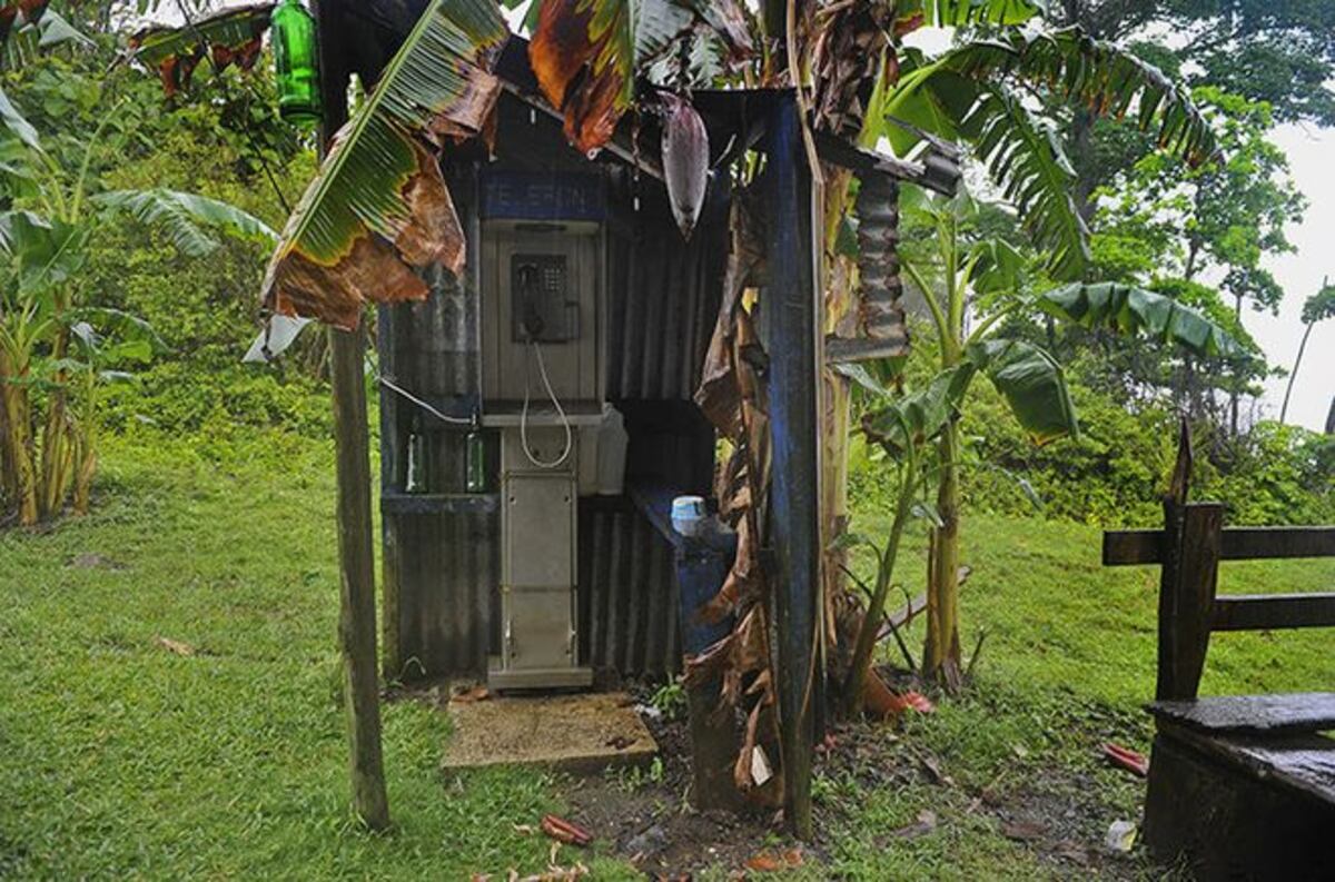 LOS PILLARON. Dos hombres vandalizando un teléfono público en Santa Librada 